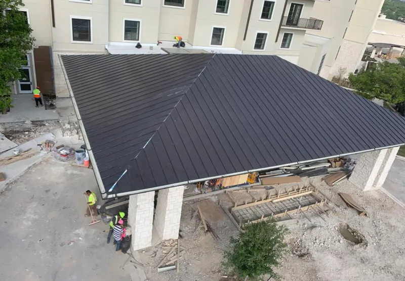 Metal roofing installation team working on a commercial building in Anderson